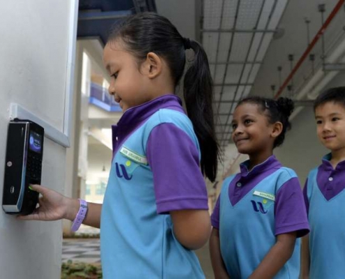 primary school kids using biometric attendance scanner